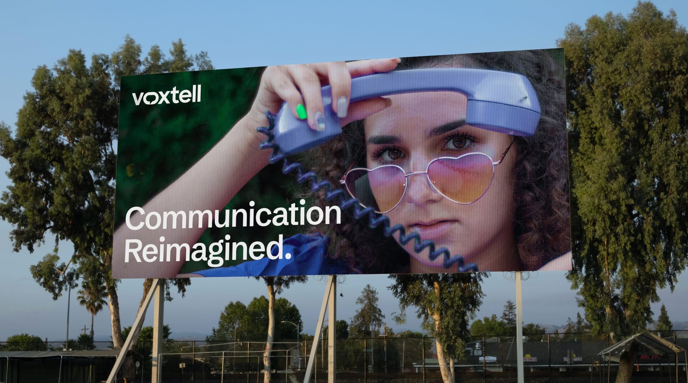 Voxtell “Communication reimagined” billboard among trees
