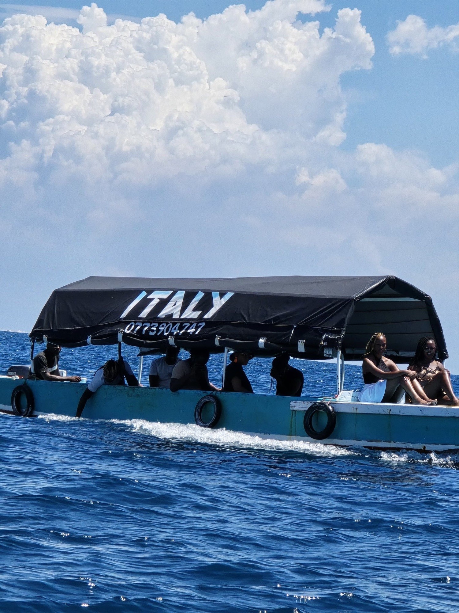 A tour boat with an Italy sign on blue water